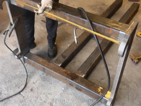 Metallista valmistettavaa putkien noston apuvälinettä mitataan